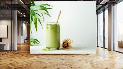 Making Japanese iced matcha latte, green tea with milk, soy milk, traditional matcha tools, with bamboo straw in glass on white background. Wall mural