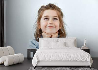 dreamy,pleased, thinking emotion . wish concept. little child girl face portrait on white backgound. Wall mural