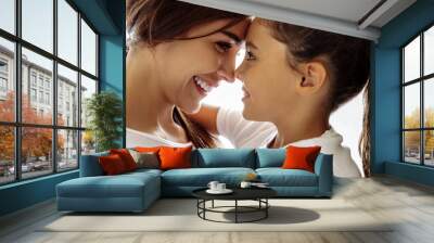 Family. Love. Togetherness. Mom and daughter are hugging, touching with their foreheads and smiling; at home Wall mural