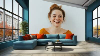 Woman portrait. Happiness. Beautiful blue eyed girl with freckles is looking away and laughing, on a white background Wall mural