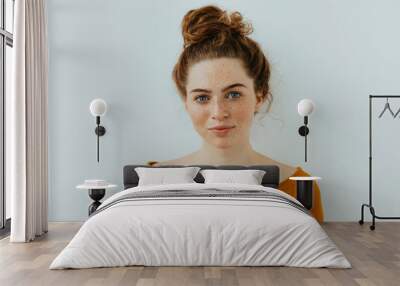 Woman portrait. Style. Beautiful blue eyed girl with freckles is looking at camera and smiling, on a white background Wall mural