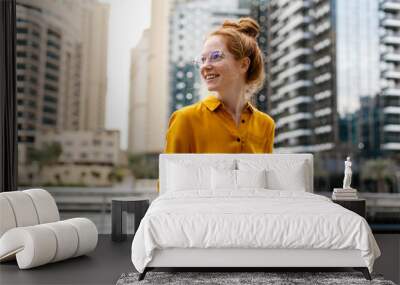 Young Woman sitting in Dubai Marina aria and work on laptop. Student or  freelancer lifestyle. Wall mural