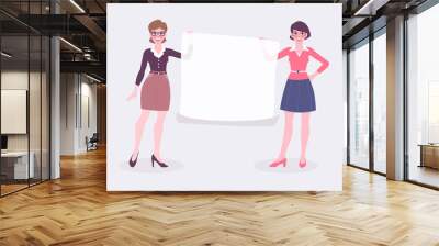 Two business women holding a blank  poster, announcement or presentation. Wall mural