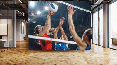 A close-up of intense volleyball match action, with players attempting to block at the net Wall mural