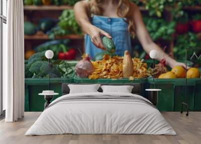 A female in casual attire systematically places vegetable peels into a compost bin, signifying the personal role in environmental sustainability Wall mural