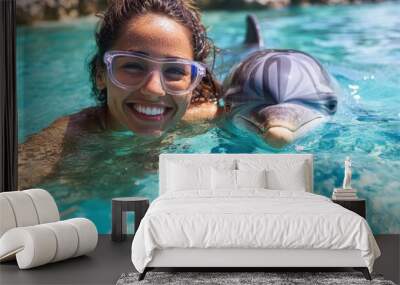 A happy scene featuring a woman swimming alongside a dolphin in the clear blue ocean water, both seemingly ecstatic, showcasing marine life interaction and joy. Wall mural