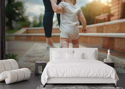 A little boy takes his first steps on a soft rug, surrounded by the vastness of the sky and the grounding presence of his loving family Wall mural