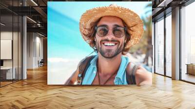 A man exudes effortless style as he smiles in his sun hat and sunglasses, the palm trees and blue sky creating a beachy backdrop for his fashionable outdoor look Wall mural