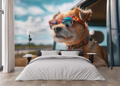 A stylish pup enjoys the sunny day with its fashionable goggles and shades, cruising in a car while taking in the breathtaking view of the sky Wall mural