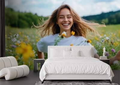 A woman with loose hair laughing joyfully as she stands in a field full of vibrant flowers, capturing the essence of carefree happiness and the beauty of nature. Wall mural