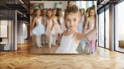 A young ballerina leads a dance class while confidently performing ballet poses Wall mural