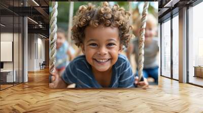 A young boy with curly hair smiling while playing outdoors on a sunny day. The image encapsulates the joy and carefree nature of childhood fun in an outdoor setting. Wall mural