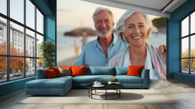 An elderly couple smiles as they walk along a scenic beach during sunset, creating a heartwarming scene of togetherness, happiness, and the beauty of lifelong companionship. Wall mural