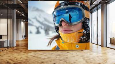 An individual dressed in an orange jacket, helmet, and goggles enjoying a day on a snowy mountain, surrounded by the winter's natural beauty and fresh powder. Wall mural