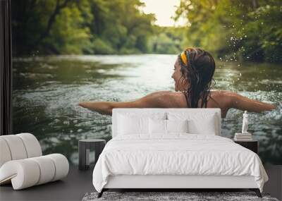 Image captured from behind, depicting a man submerged in a river, surrounded by a tranquil natural environment Wall mural