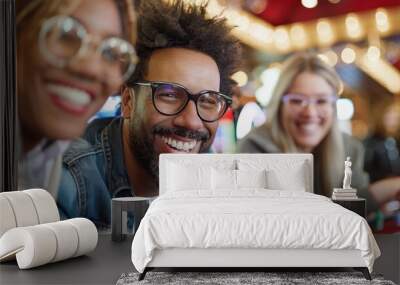 Three friends are having a fun casino night, smiling and laughing as they sit close together at a gaming table with chips, under the vibrant casino lights. Wall mural