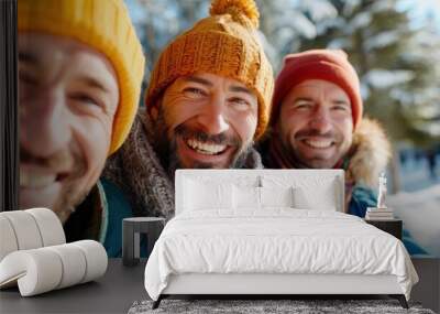 Three men enjoying a sunny winter day outdoors, dressed in warm winter clothes, smiling and holding hot drinks, with snow-covered trees in the background. Wall mural