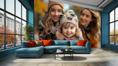 Two women and a young child pose with joyous expressions during fall Wall mural