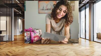 Close-up woman receive gift box. Smiling while reading a greeting card. Sharing, friendship, anniversary, give concept. Wall mural