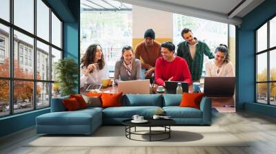 Front view group on young multiracial people with happy smiling faces working in a teamwork sitting at table. Wall mural