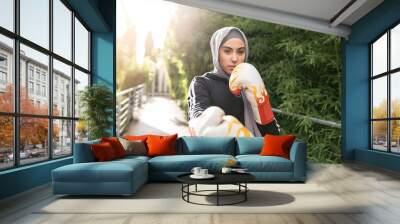 Arab female athlete of islamic faith practicing boxing outdoors - muslim woman practicing boxing - Wall mural