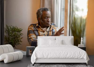 elderly pensioner at home sad looks out the window serious Wall mural