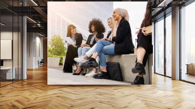 multiracial coworkers sitting lounging outside having lunch on steps Wall mural