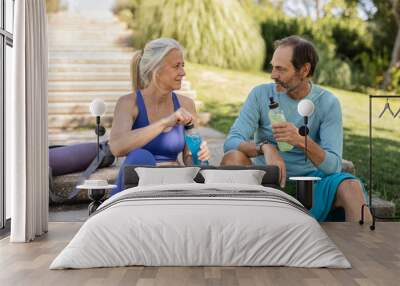 senior couple athletes rest drinking energy drink Wall mural