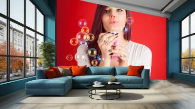 Beautiful woman portrait with soap bubble against colorful red b Wall mural