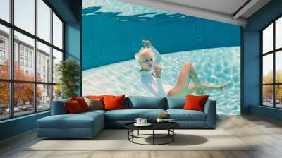 Beautiful woman wearing white swimsuit underwater in swimming po Wall mural