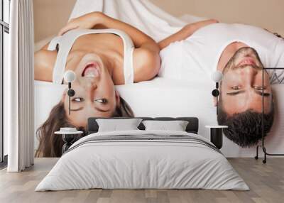 Happy young couple portrait having fun upside down in hotel room Wall mural