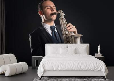 Saxophone player man isolated against black background. Close up Wall mural