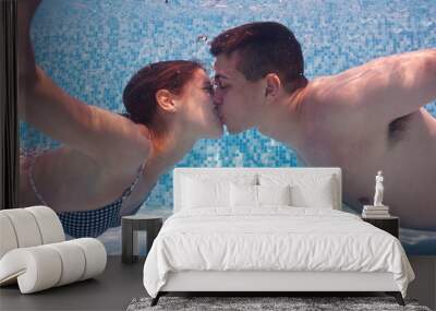 Underwater couple kissing in swimming pool. Wall mural