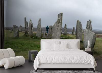 Girl, traveler stainding inside the Calanais Standing Stones in Outer Hebrides, Isle of Lewis, Scotland, UK. Moody and rainy weather. Wall mural