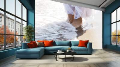 Pictore of feet on a beach and water. Wall mural