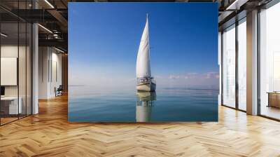 Sailboat calm day with blue sky forward. Wall mural