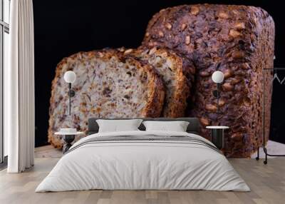 Tasting bread with seeds on a wooden board. Fresh dark bread on the kitchen table. Wall mural