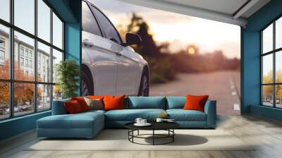 Behind a beautiful white car parked on a road with beautiful sunsets. with space for text. Wall mural