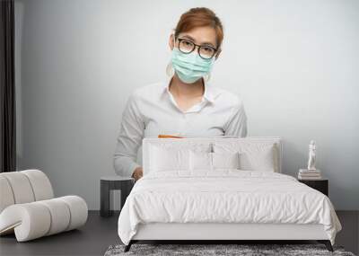 Office lady in glasses wearing white shirt holding a folder on a white background Wall mural