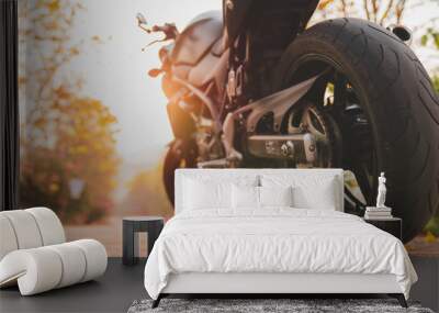 The part of the motorcycle parked on the road is warm ligth. . Wall mural