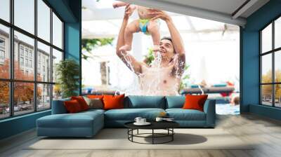 father plays with the baby boy in the pool Wall mural