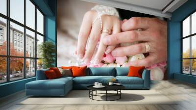 Hands of the groom and the bride with wedding rings and a weddin Wall mural