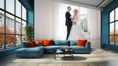 Happy bride and groom at the wedding walk in front window Wall mural