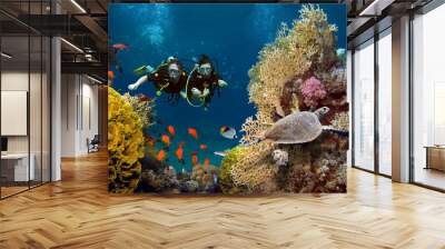 The loving couple dives among corals and fishes in the ocean Wall mural