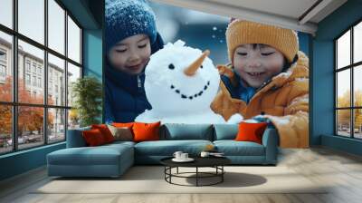 Two happy children a young boy and girl playing together and building a cheerful snowman in a serene snowy winter landscape with trees and a frozen lake or pond in the background Wall mural