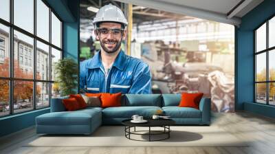 Confident engineer in blue jumpsuit with hard hat smling in the warehouse.	
 Wall mural