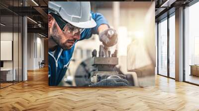 Male engineer in blue jumpsuit and white hard hat operating lathe machine.	
 Wall mural