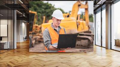 Caucasian young engineer using a laptop on road construction site. Engineer work concept Wall mural