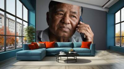 Portrait, unhappy elderly man thinking while using smart phone at home, sad old man Wall mural