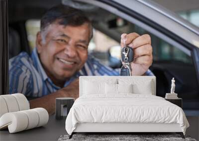 Selective focus on car keys. Happy smiling elderly Asian man in new car at the dealership. Wall mural